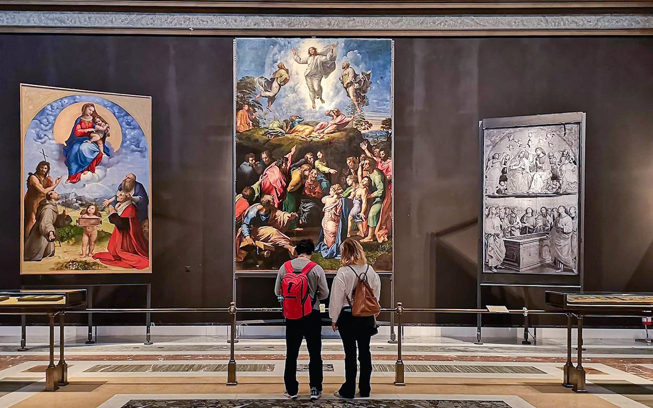 Visitors viewing Raphael's Transfiguration painting at the Vatican's Pinacoteca.