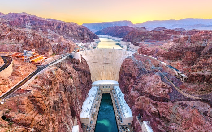 Hoover Dam spanning Colorado River at sunset, USA.