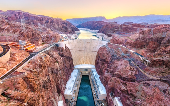 Hoover Dam spanning Colorado River at sunset, USA.