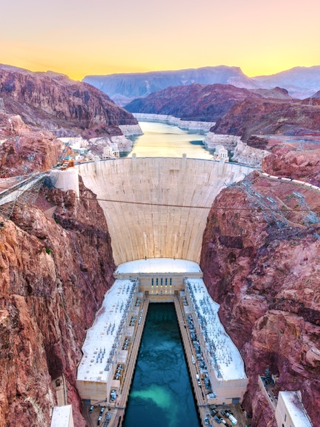 Hoover Dam spanning Colorado River at sunset, USA.