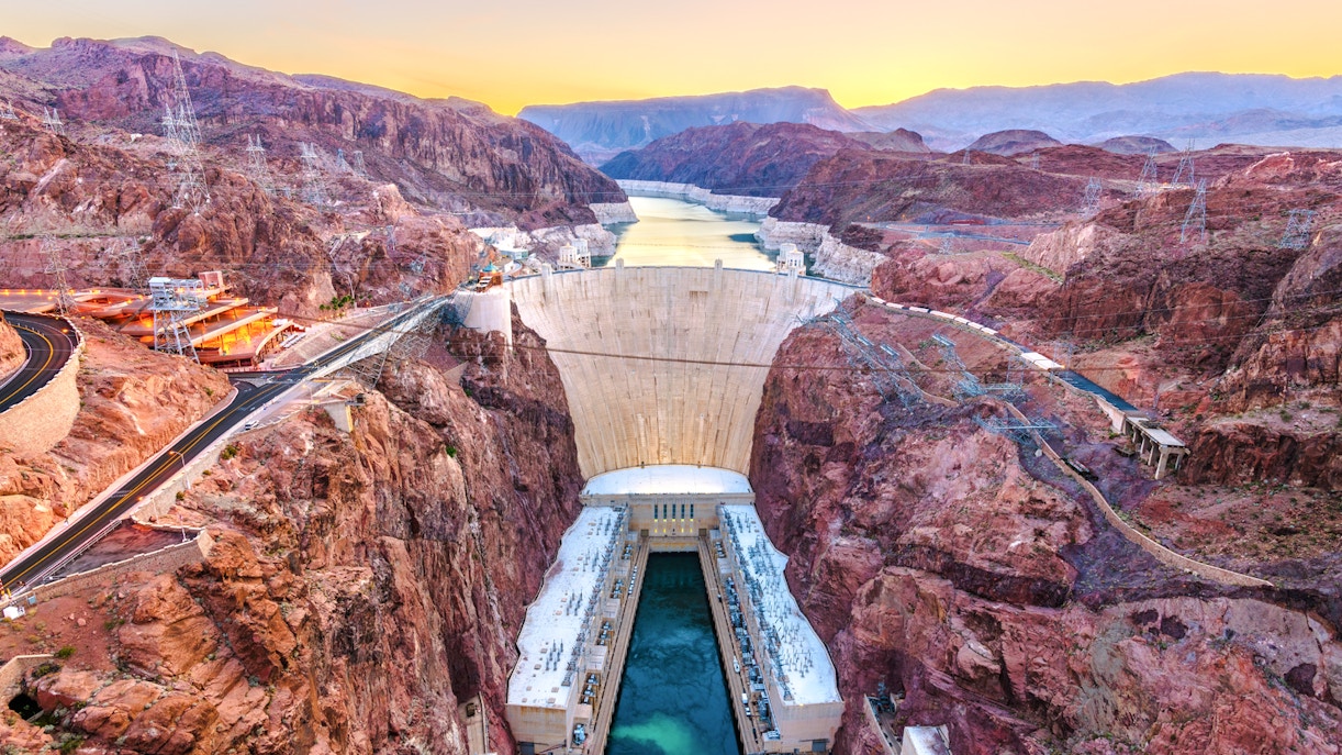 Hoover Dam spanning Colorado River at sunset, USA.
