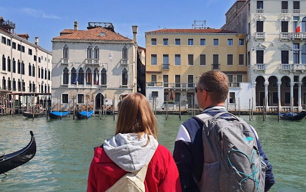 Tourists viewing Venetian architecture from a canal during a small group tour in Venice.