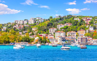 Boats on the Bosphorus with Bebek district hillside in Istanbul.