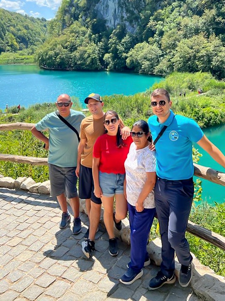 Guests standing by a turquoise lake at Plitvice Lakes National Park, Croatia.