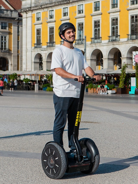 Tourists riding Segways in a historic European square.