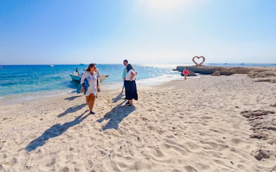 Tourists on a sandy beach near a boat during a high-speed sea taxi tour to Orange Bay.