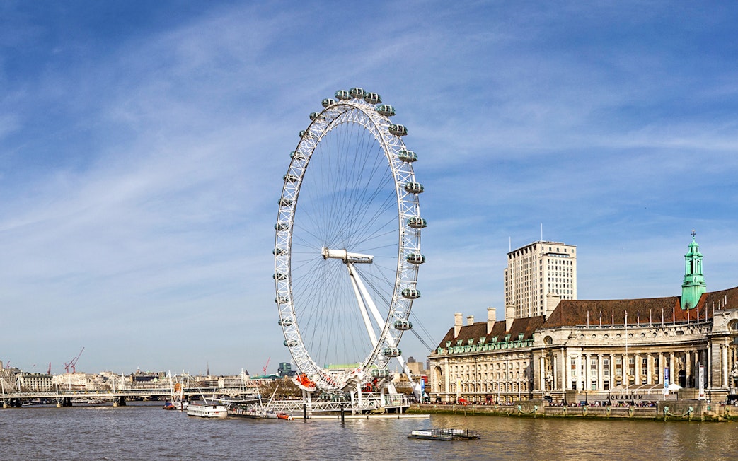 Thames River view with the London Eye and nearby buildings on a sightseeing cruise.