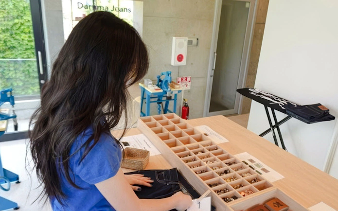 Woman assembling denim jeans at Harajuku workshop in Tokyo.