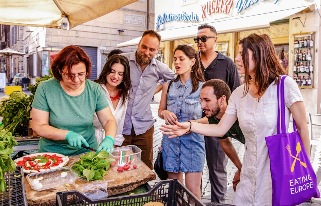 Tour group with Signora Cristina at a local market in Rome during a food tour.