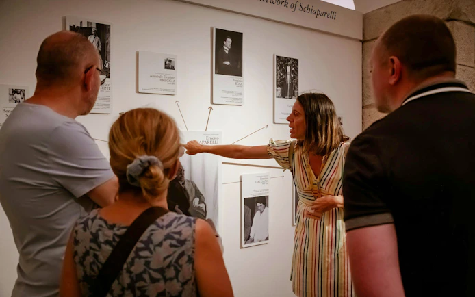 Guide explaining exhibits at the Egyptian Museum in Turin to visitors.