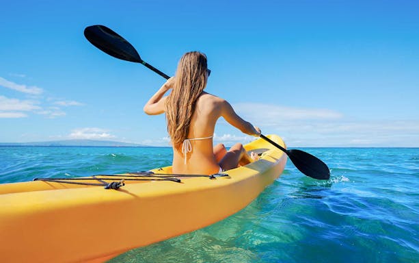 Person kayaking on clear blue waters in Dubai.