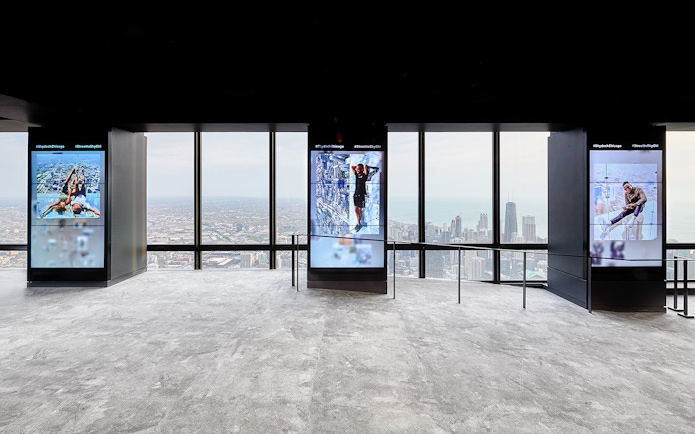 View from Skydeck at Willis Tower, Chicago, overlooking cityscape and Lake Michigan.