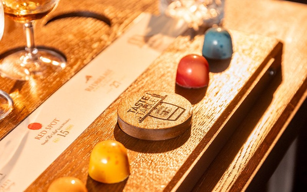 Jameson whiskey and colorful chocolates on a tasting board in a Dublin bar.