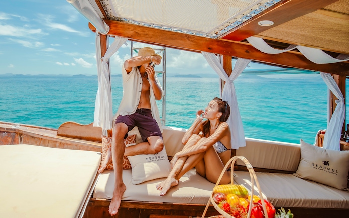 Couple relaxing on a luxury longtail boat in Krabi, enjoying the ocean view.