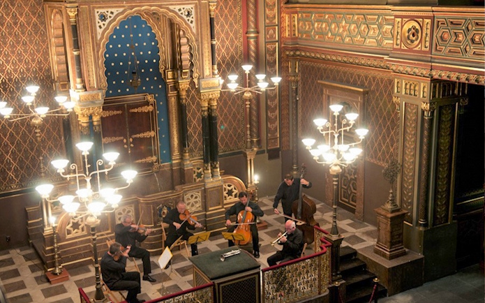 Classical concert in Prague's Spanish Synagogue with musicians performing.
