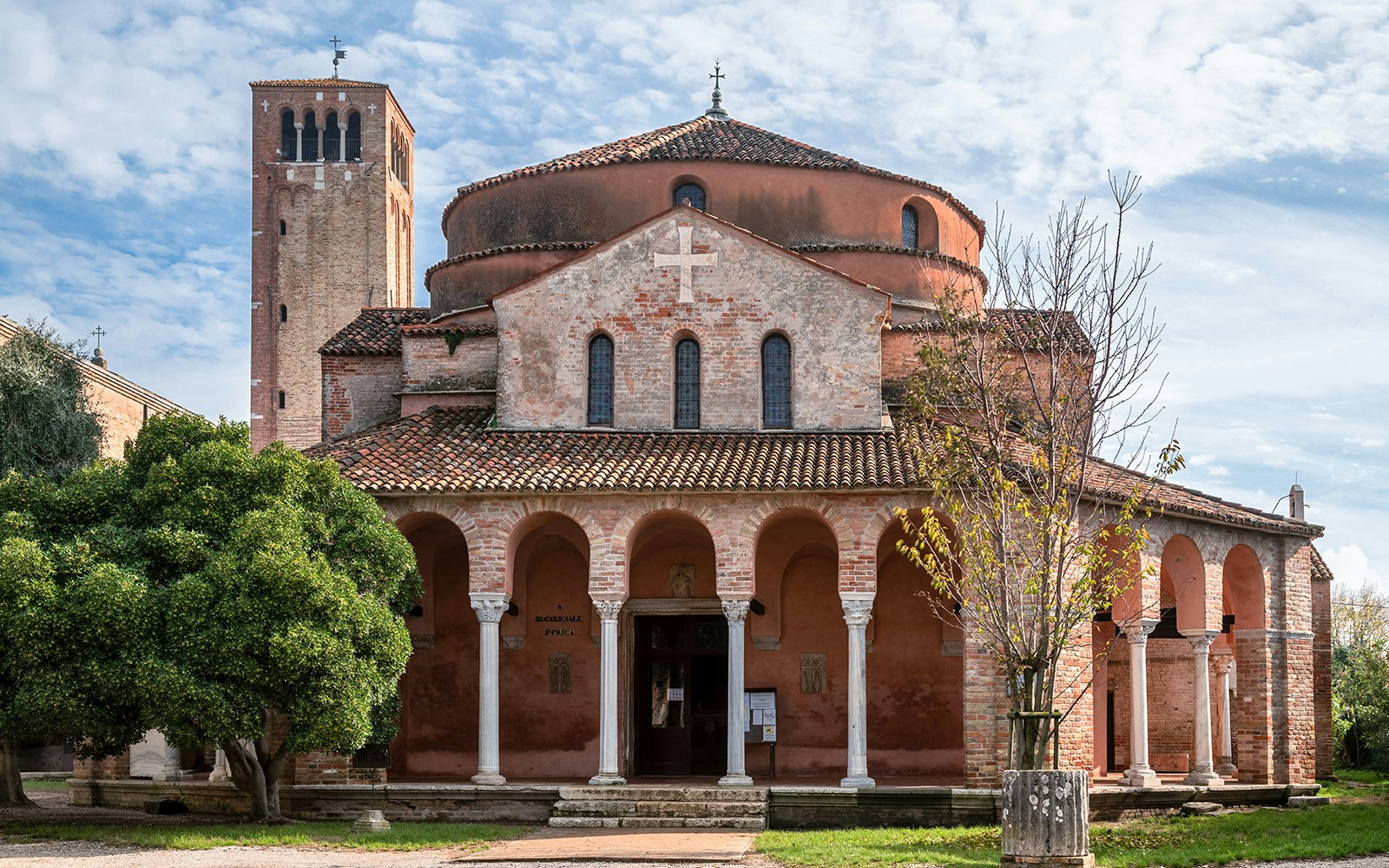 Torcello Island canal with ancient church near Venice.