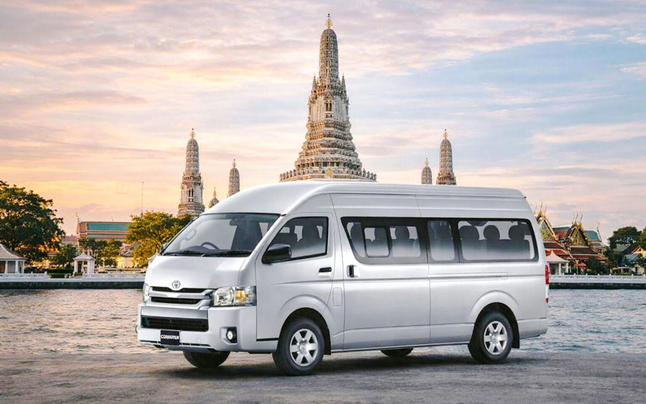 Minivan in front of Wat Arun temple, Bangkok, for private airport transfer.