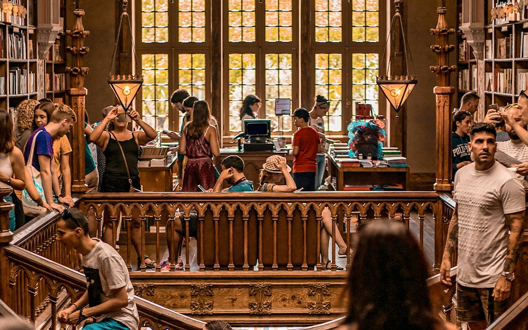 Tourists exploring the interior of Lello Library in Porto, Portugal.