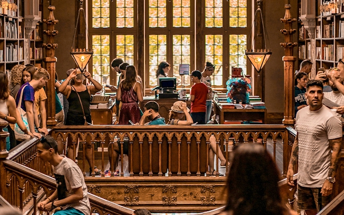 Tourists exploring the interior of Lello Library in Porto, Portugal.