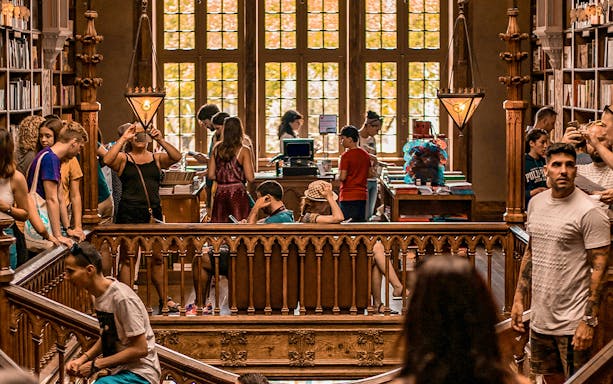 Tourists exploring the interior of Lello Library in Porto, Portugal.