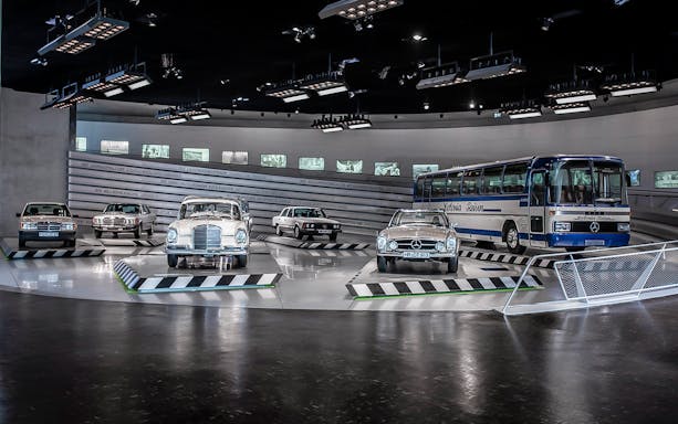 Classic Mercedes-Benz vehicles displayed inside Mercedes-Benz Museum.