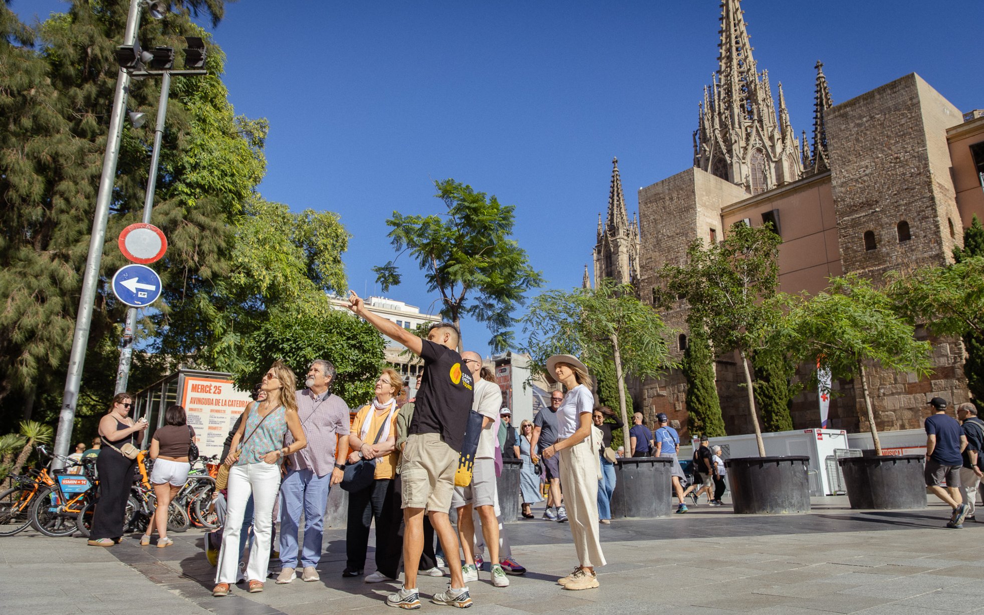 Tourists exploring the Gothic Quarter in Barcelona with the Barcelona Cathedral in the background.