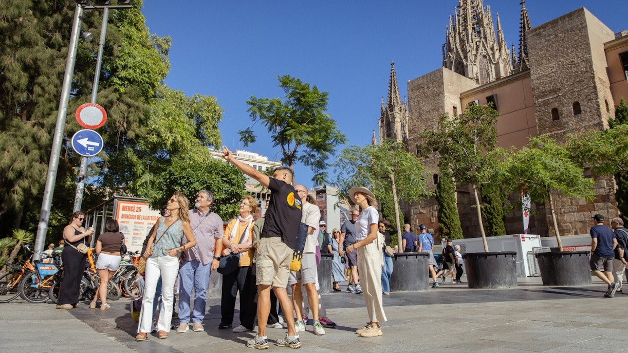 Tourists exploring the Gothic Quarter in Barcelona with the Barcelona Cathedral in the background.