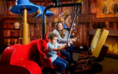 Child and adult enjoying interactive ride at LEGOLAND Discovery Centre.