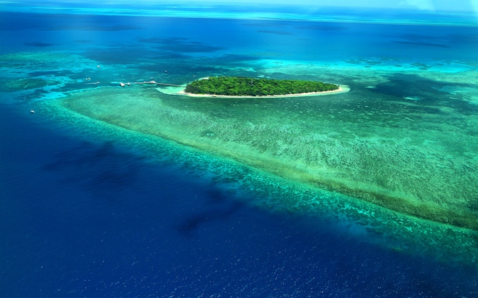 Aerial view of the Great Barrier Reef's outer edges with vibrant coral and clear blue water.