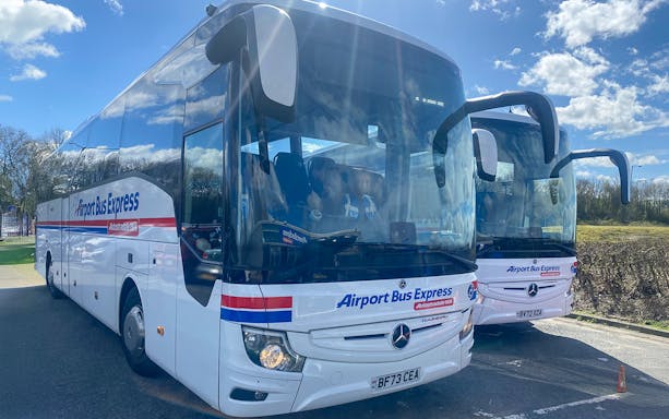 Airport Bus Express coaches parked, offering one-way tickets from London Stansted Airport to London Stratford.
