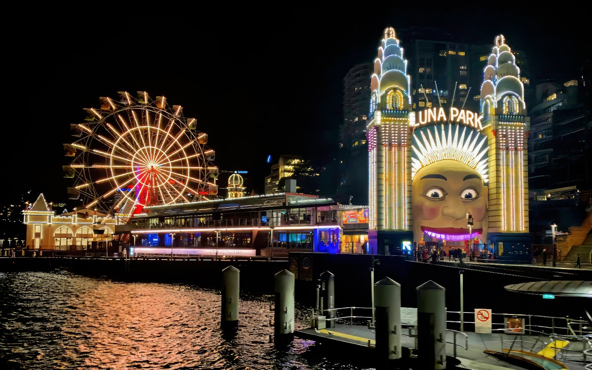 Luna Park entrance and Ferris wheel illuminated at night, Sydney Night Tour.