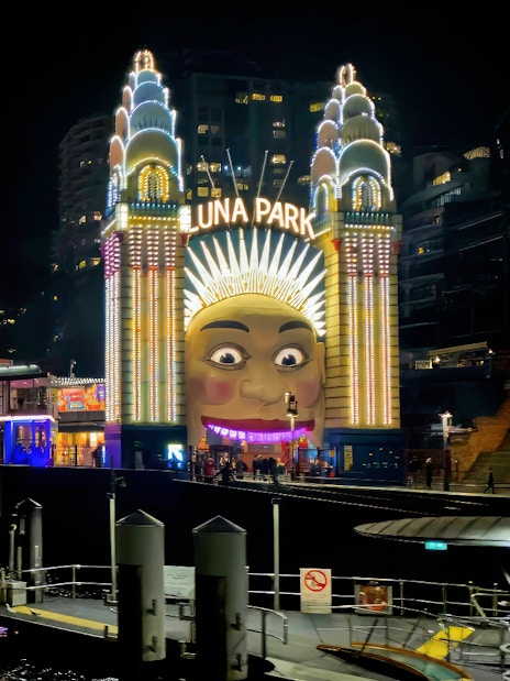 Luna Park entrance and Ferris wheel illuminated at night, Sydney Night Tour.