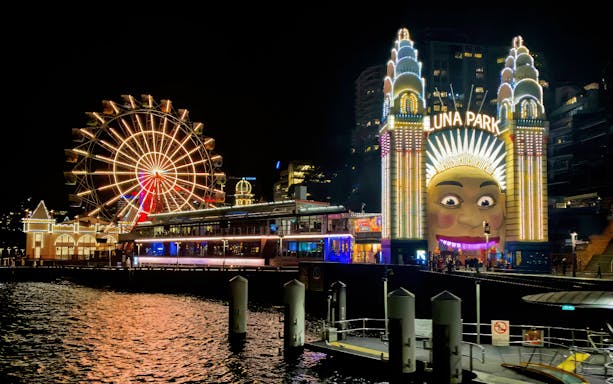 Luna Park entrance and Ferris wheel illuminated at night, Sydney Night Tour.