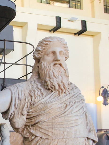 Roman sculpture at Centrale Montemartini, Rome, with industrial backdrop.