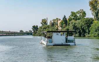 Eco-friendly boat cruising on the Guadalquivir River in Seville, Spain.