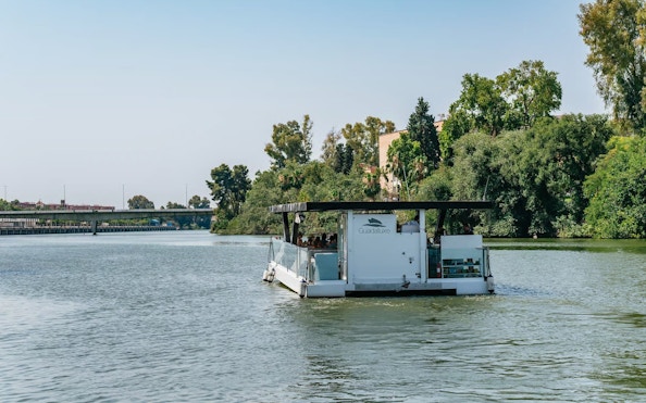 Eco-friendly boat cruising on the Guadalquivir River in Seville, Spain.