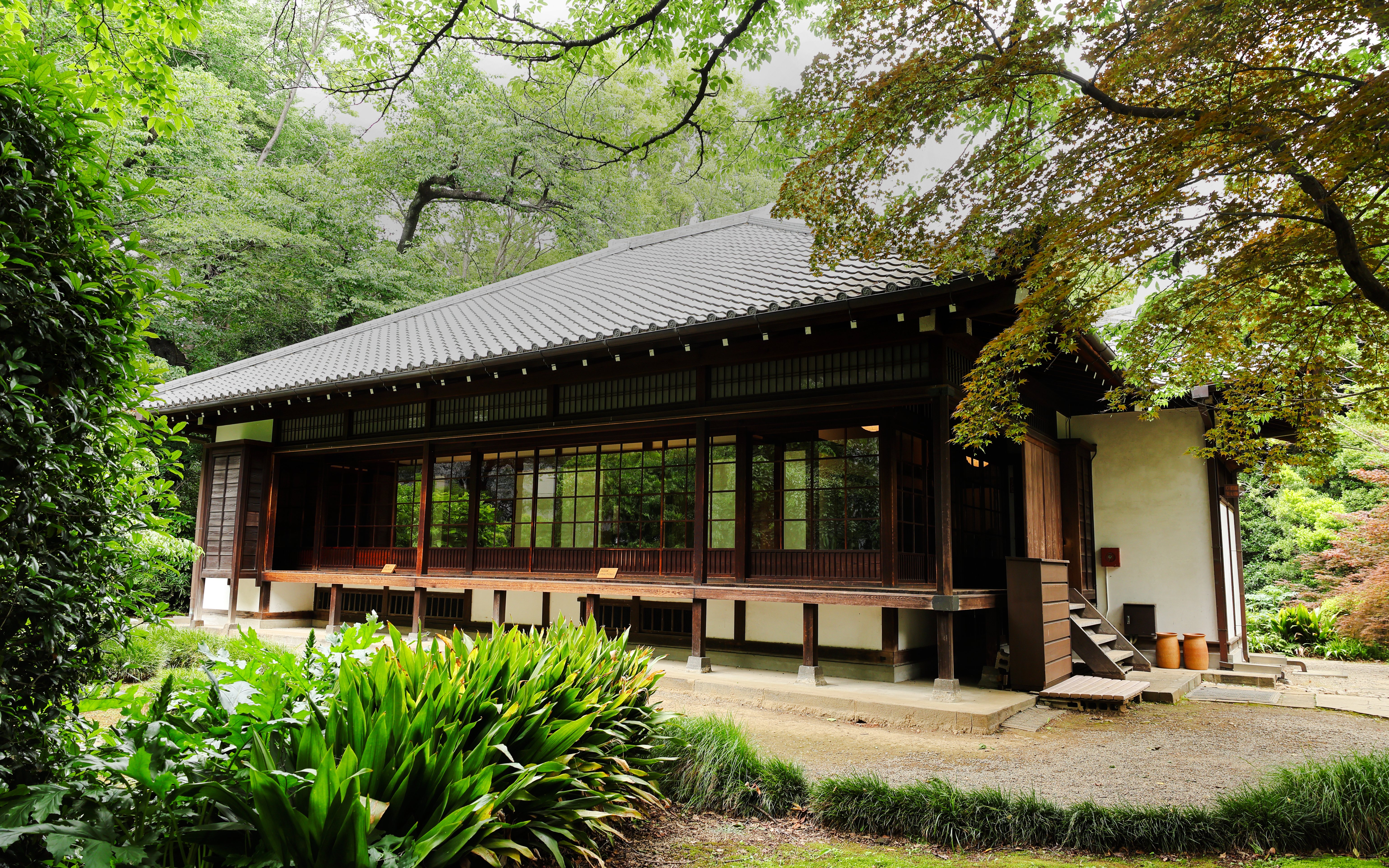 Historic Okyokan tea house in Tokyo National Museum's Japanese Garden, surrounded by lush greenery.