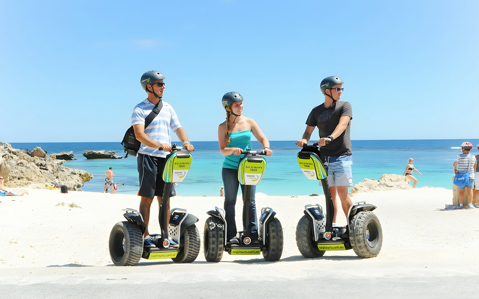 Tourists on Segways at Rottnest Island beach with ocean view.