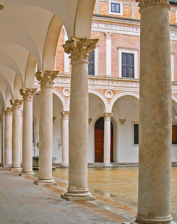 Palazzo Ducale di Urbino courtyard with ornate columns and arches.