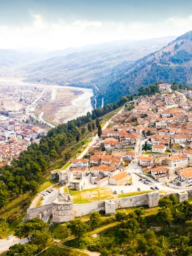 Aerial view of Berat, Albania with castle walls and tiled roofs.