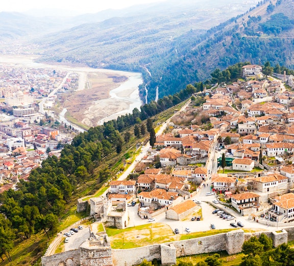 Aerial view of Berat, Albania with castle walls and tiled roofs.