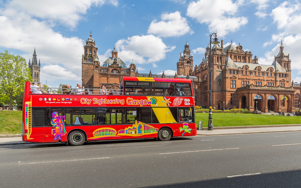 Open-top sightseeing bus in front of Kelvingrove Art Gallery, Glasgow.