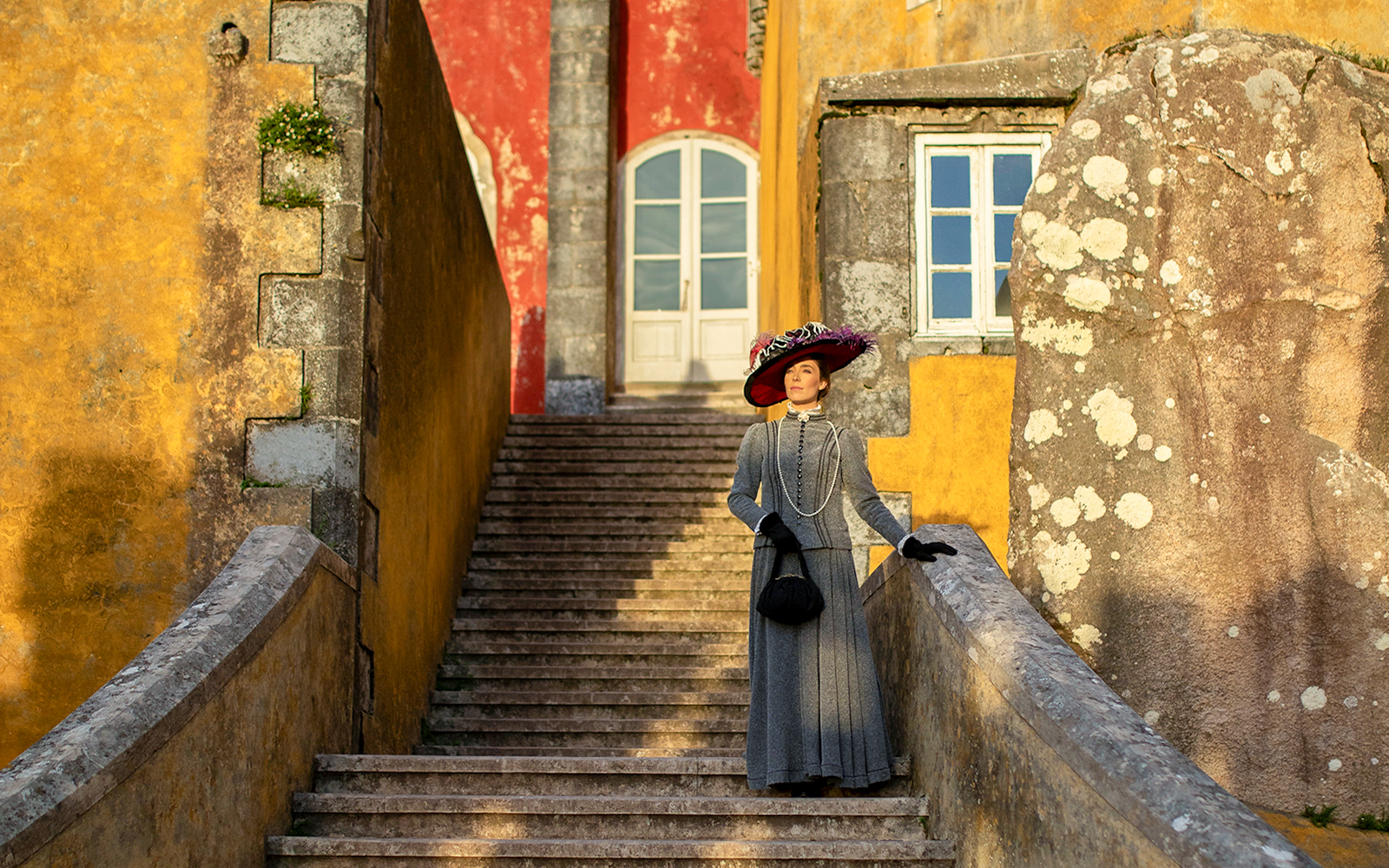 Visitor in period costume on stairs at Palace of Pena, Sintra, Portugal.
