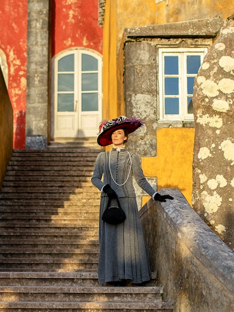 Visitor in period costume on stairs at Palace of Pena, Sintra, Portugal.