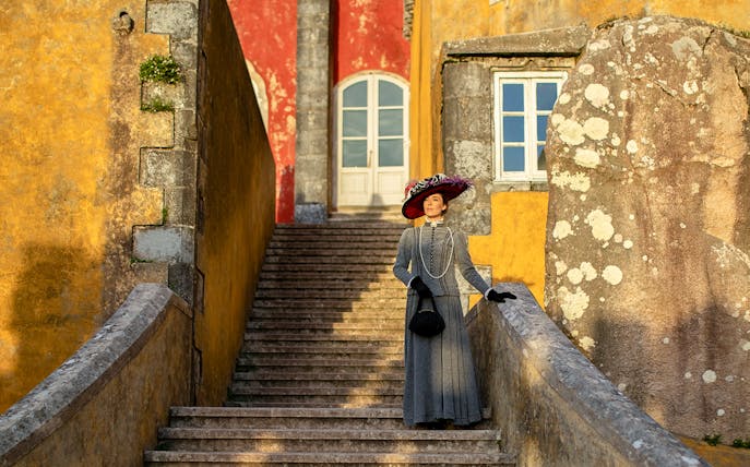 Visitor in period costume on stairs at Palace of Pena, Sintra, Portugal.