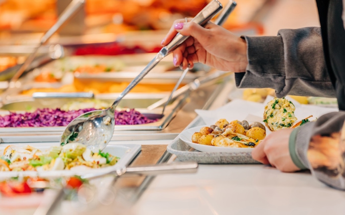 Serving food at buffet in Vibes Bar & Kitchen with various dishes.