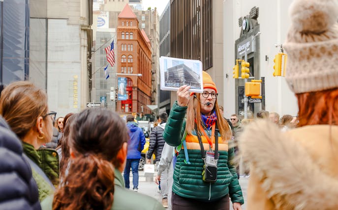 Tour guide in New York City showing a photo of the original World Trade Center.