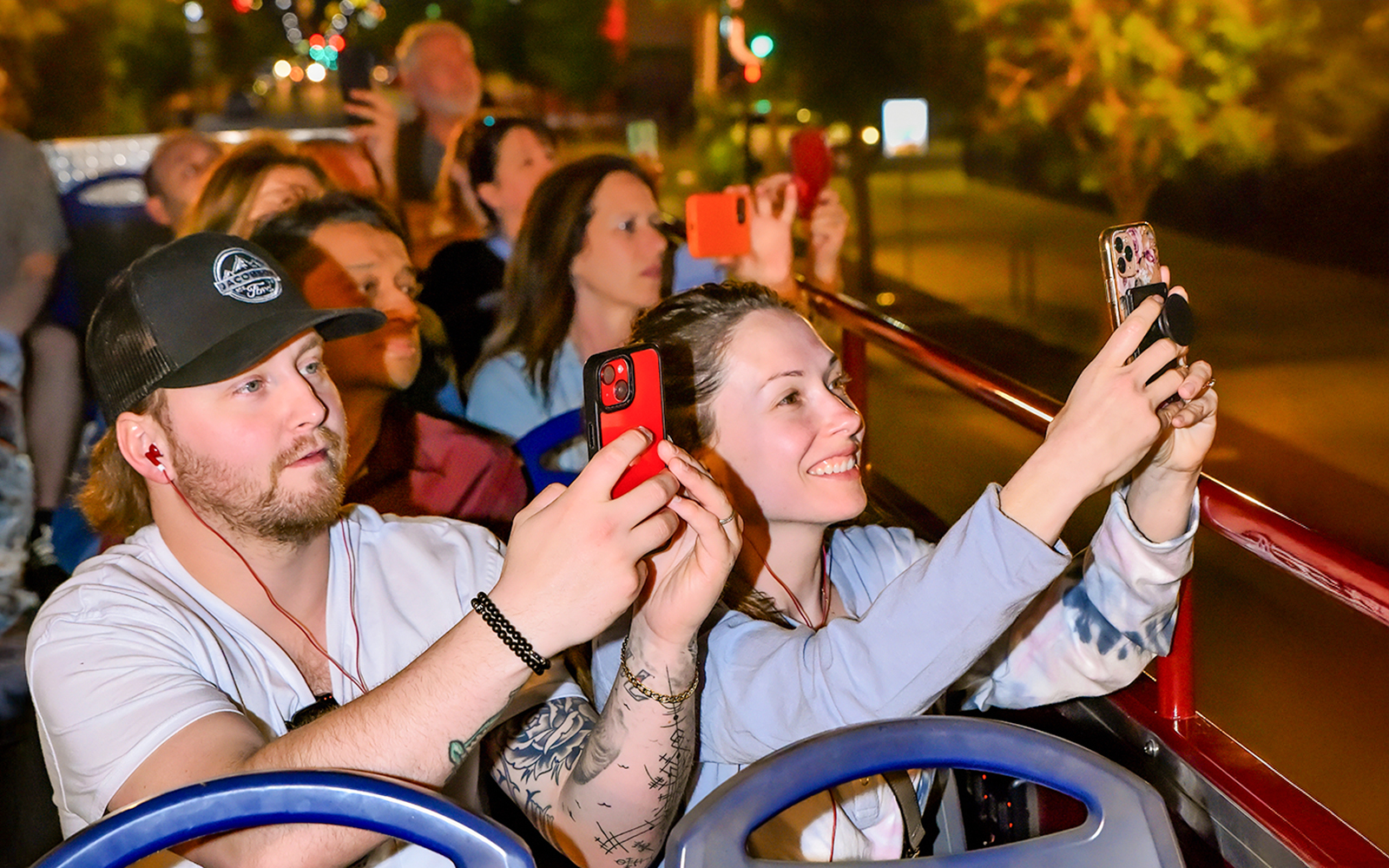 Tourists taking photos on a night Big Bus Tour in Las Vegas.