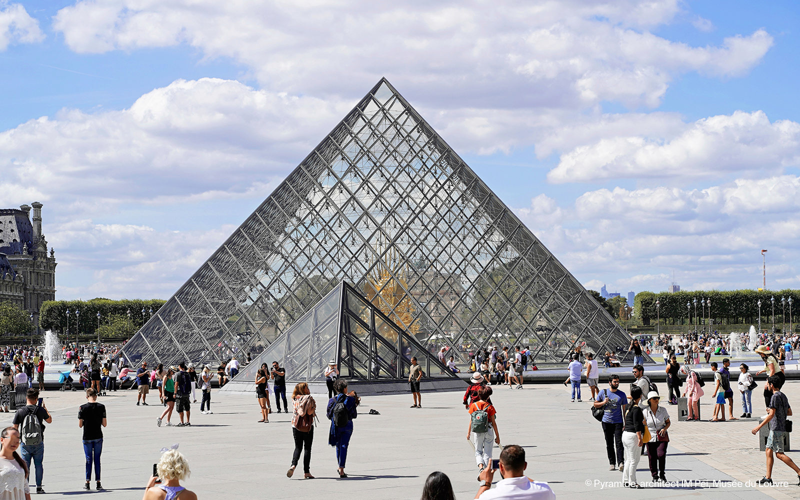 Louvre Museum glass pyramid entrance in Paris, France.