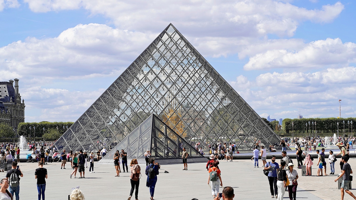 Louvre Museum glass pyramid entrance in Paris, France.